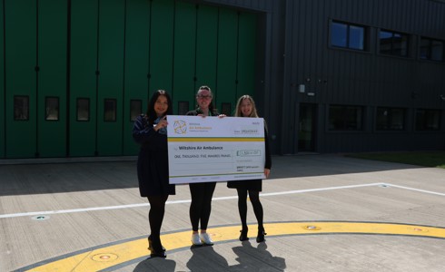 A photo of two women from Barratt David Wilson Homes presenting a cheque