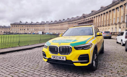 Wiltshire Air Ambulance's yellow and green BMW critical care car parked at the Royal Crescent in Bath