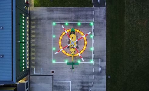 An aerial view of the WAA helicopter on a lit helipad at the charity's airbase