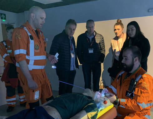 Two paramedics giving demonstrations to visitors inside the charity's iSim training facility.