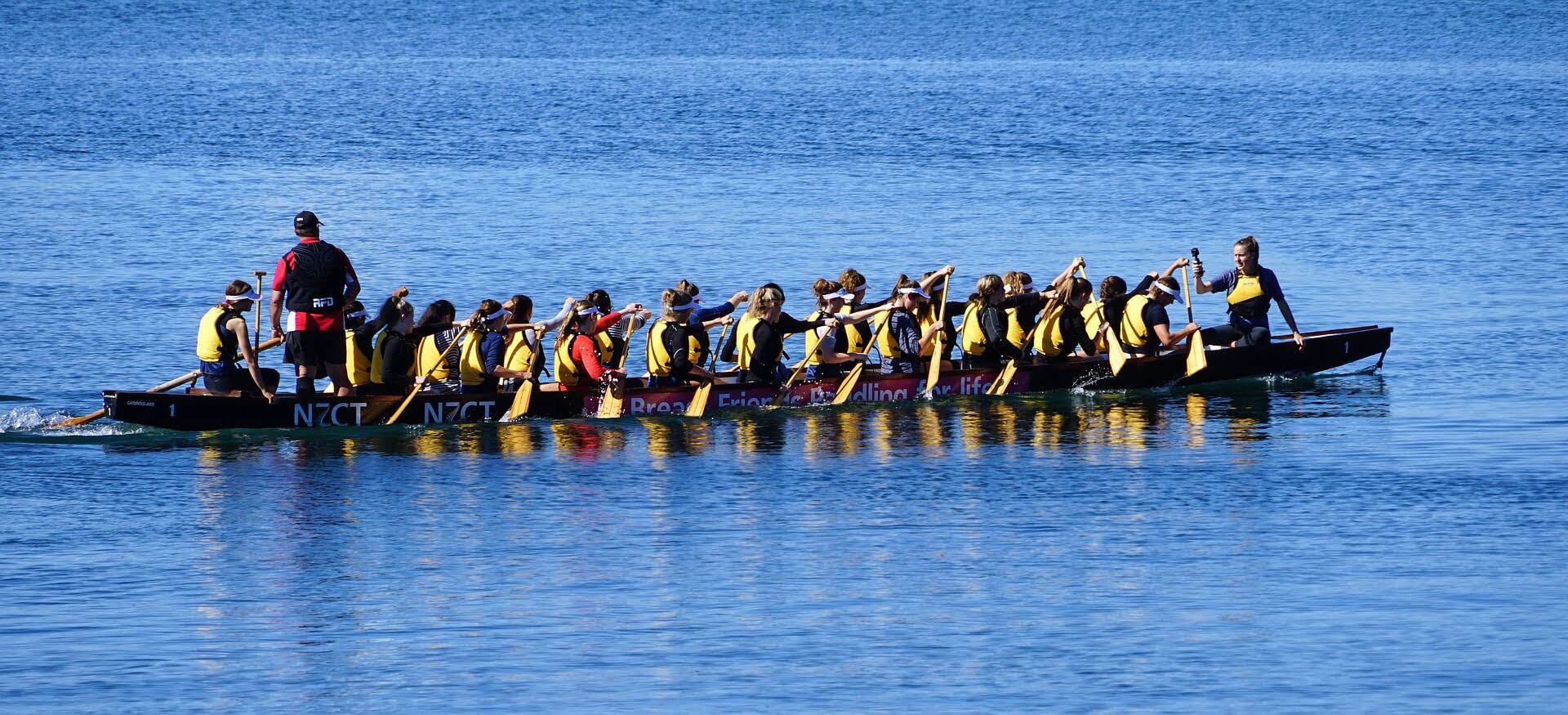 Team of people rowing a dragon boat