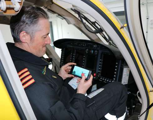 A pilot playing a helifun game on their phone inside the cockpit of the Bell-429 helicopter.