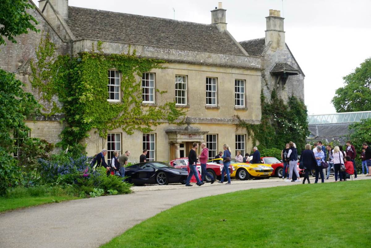 A photo of Middlewick House with sports cars parked outside and visitors taking photos and looking at the cars.