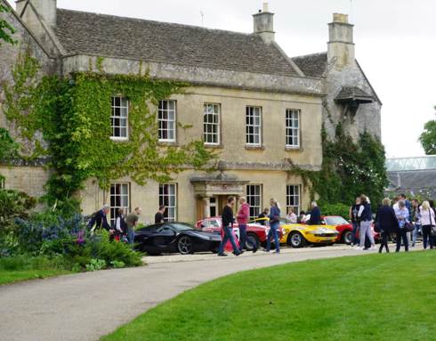 A photo of Middlewick House with sports cars parked outside and visitors taking photos and looking at the cars.