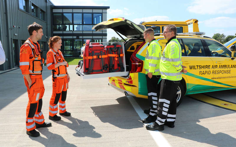 Two paramedics showing AA roadside recovery staff the equipment used in the critical care car.
