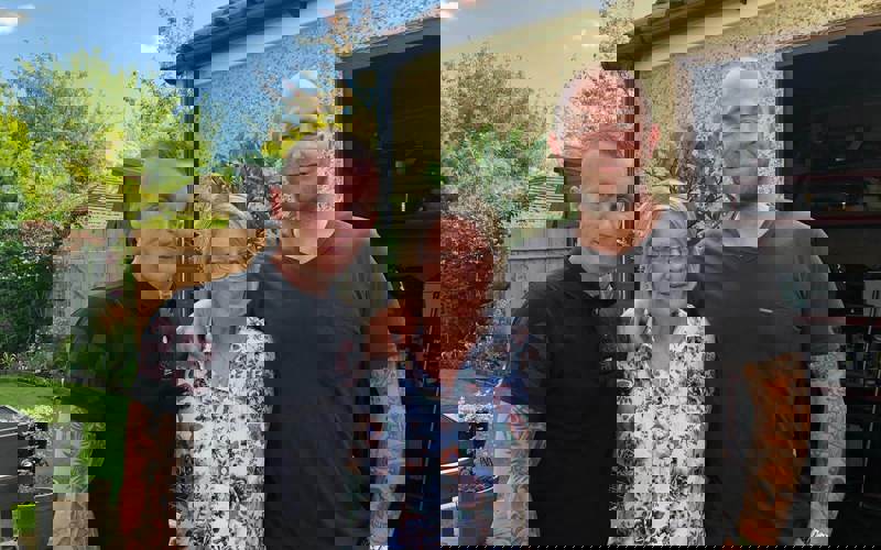 A former patient with their two children stood in a garden