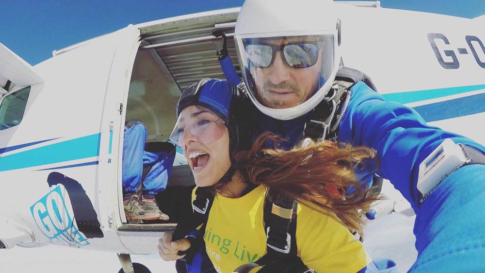 Fundraiser taking part in a skydive, wearing a Wiltshire Air Ambulance yellow t-shirt