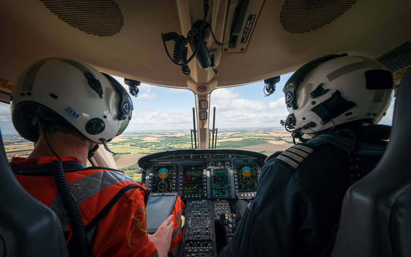 A paramedic and pilot sat in the cockpit of the helicopter whilst in flight.