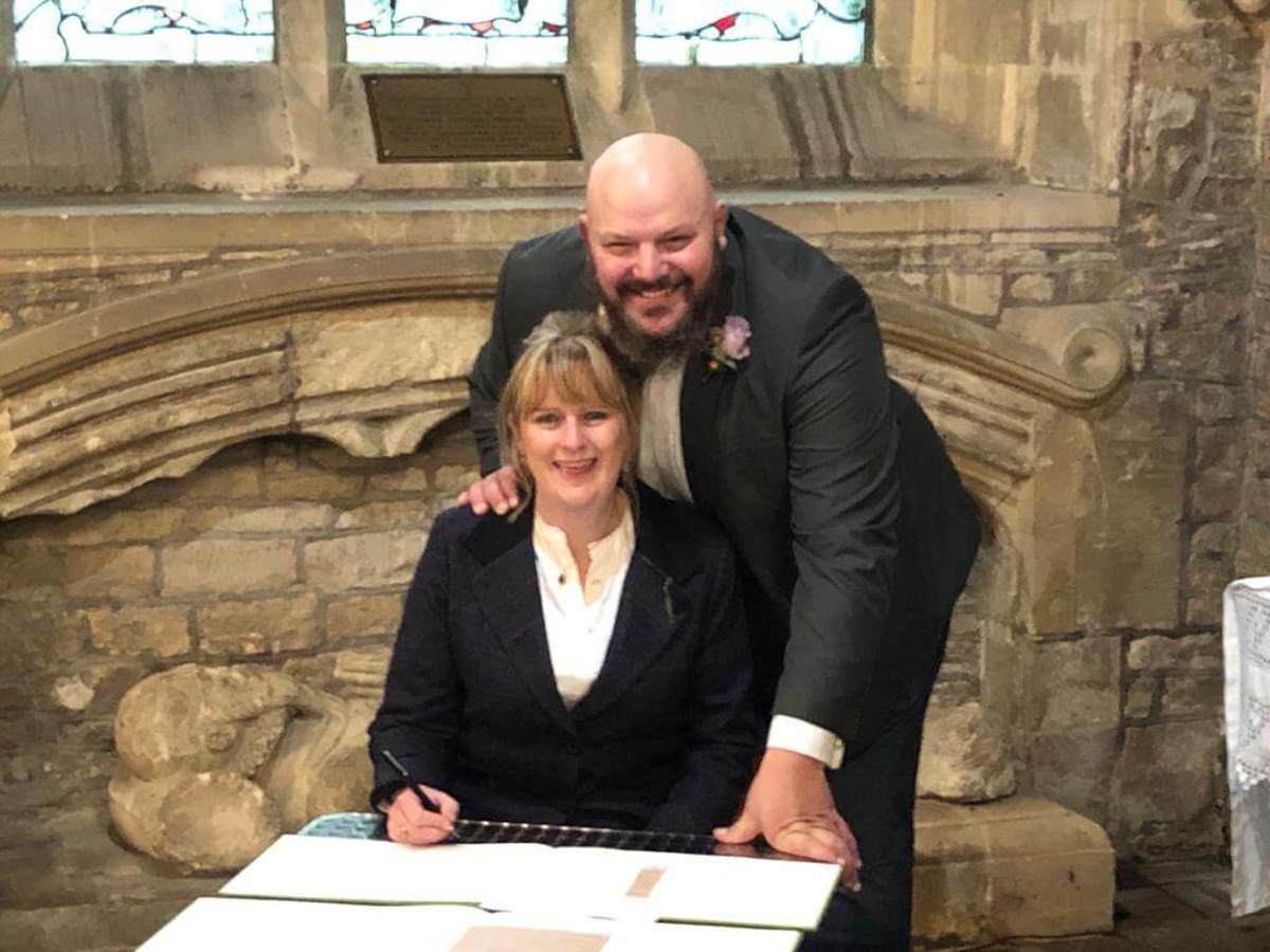 A happy couple signing a register on their wedding day