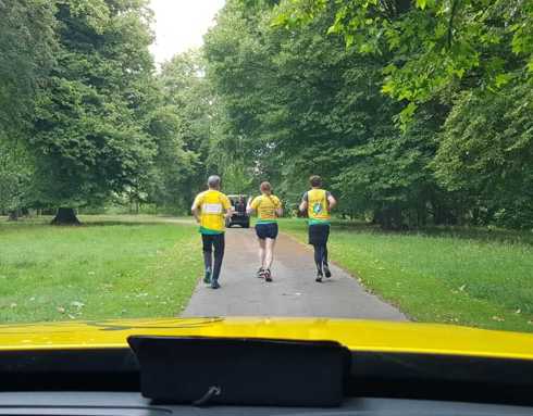 Three members of the aircrew taking part in a running challenge down a driveway at Longleat House.