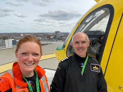 Paramedic Sophie and pilot Rob taking a selfie on the BRI helipad, with Wiltshire Air Ambulance's helicopter in the background