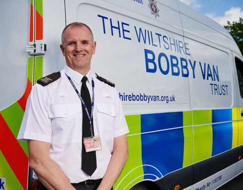 A member of the Wiltshire Bobby Van stood in front of a branded van