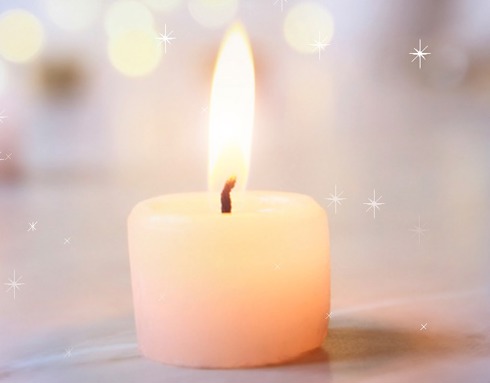 A photo of  a lit candle with sparkles