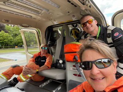 Paramedic Emma sat in the back of the Wiltshire Air Ambulance helicopter, whilst paramedic Lou and pilot Fin are taking a selfie
