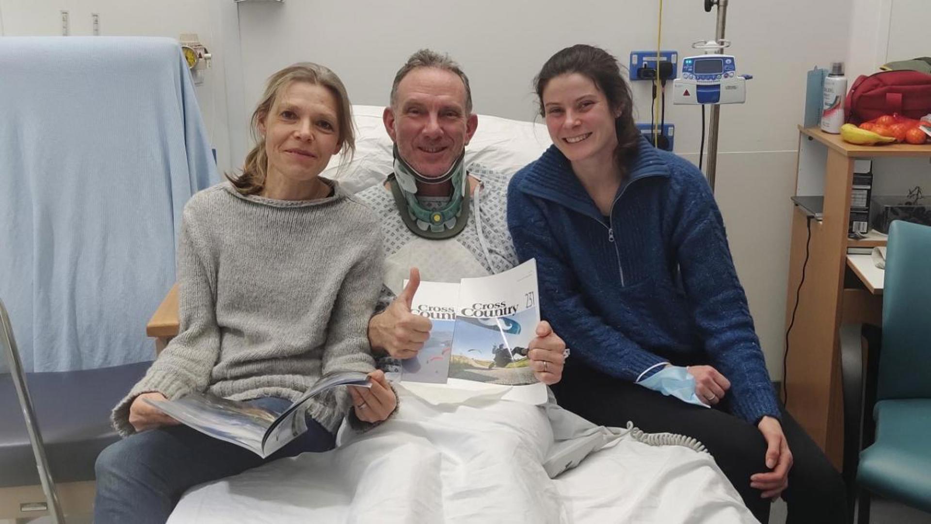 Three people sat on a hospital bed