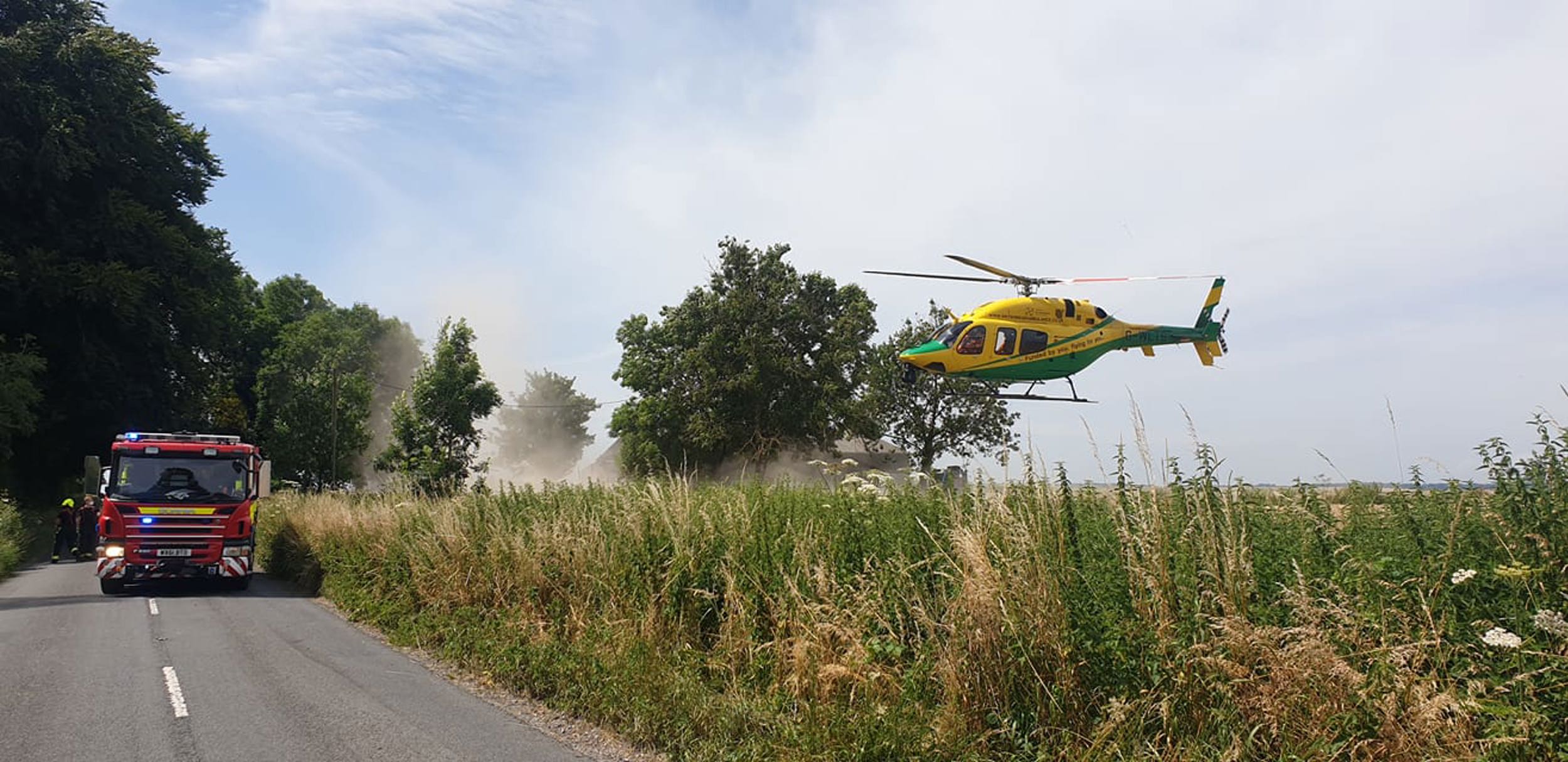 Wiltshire Air Ambulance taking off next to a fire engine in Mere