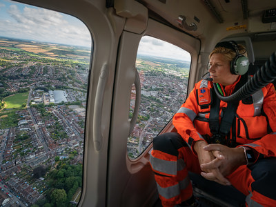 Emma Thompson sitting in the back of Wiltshire Air Ambulance's helicopter admiring the view.