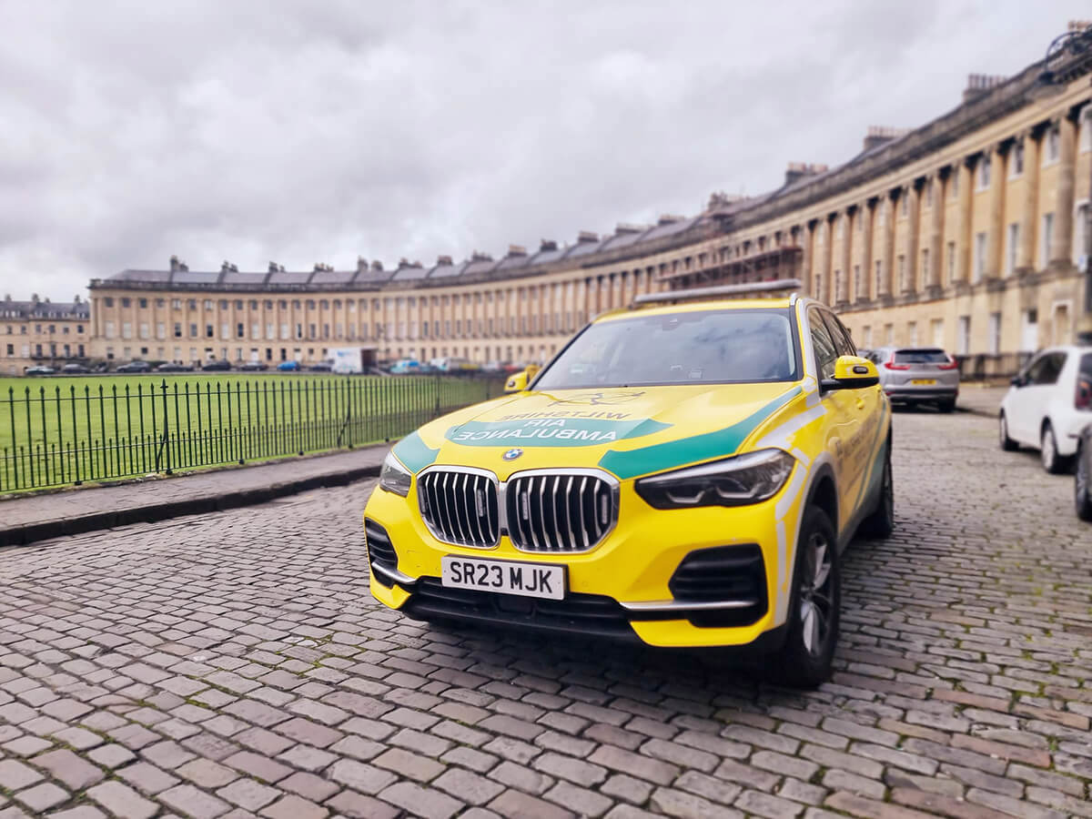 Wiltshire Air Ambulance's yellow and green BMW critical care car parked at the Royal Crescent in Bath