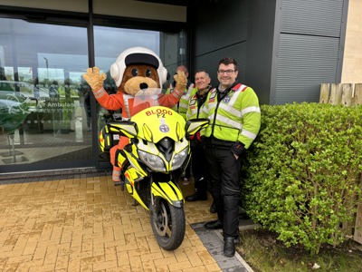 A paramedic bear mascot on a blood bike, with three other blood bikers posing