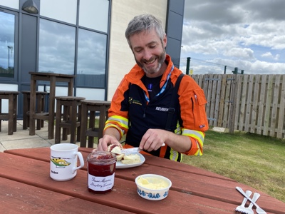 Dr Reuben Cooper enjoying tea and scones in the Wiltshire Air Ambulance garden.