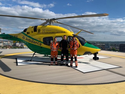 Paramedic Rich Miller, Pilot Rob Collingwood and Paramedic Adam Khan standing in front of the Wiltshire Air Ambulance helicopter on the BRI helipad