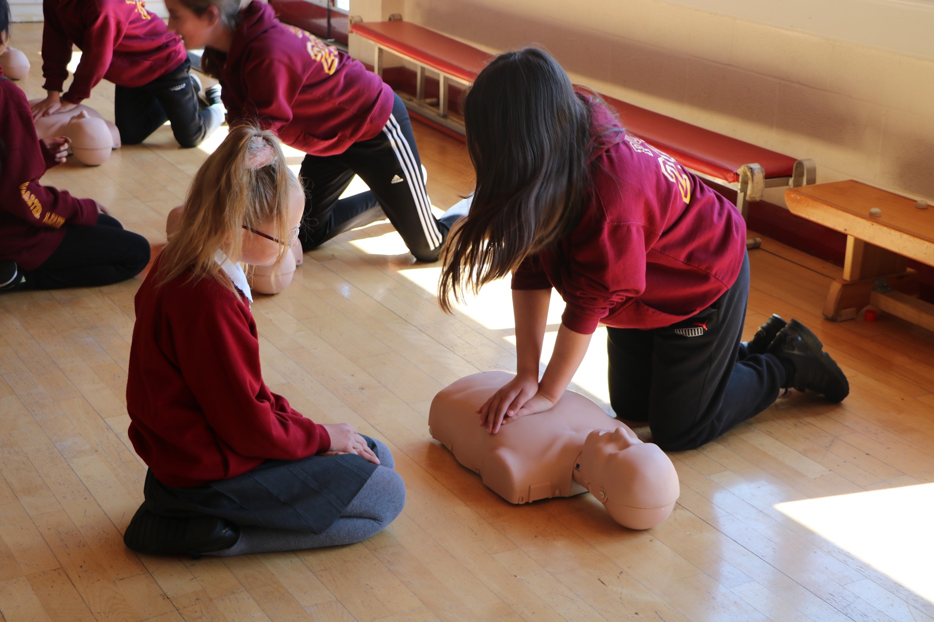 School children practicing CPR on a manekin