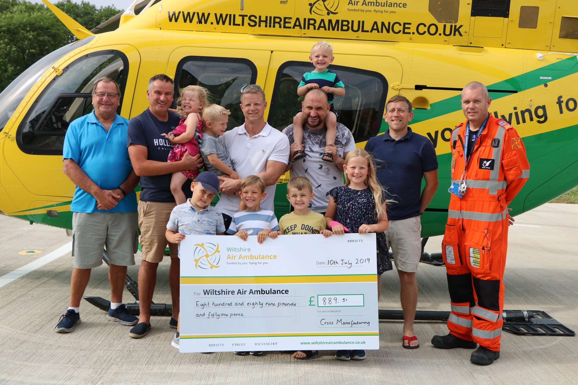 A group of adults and children from Cross Manufacturing presenting a cheque to WAA in 2019