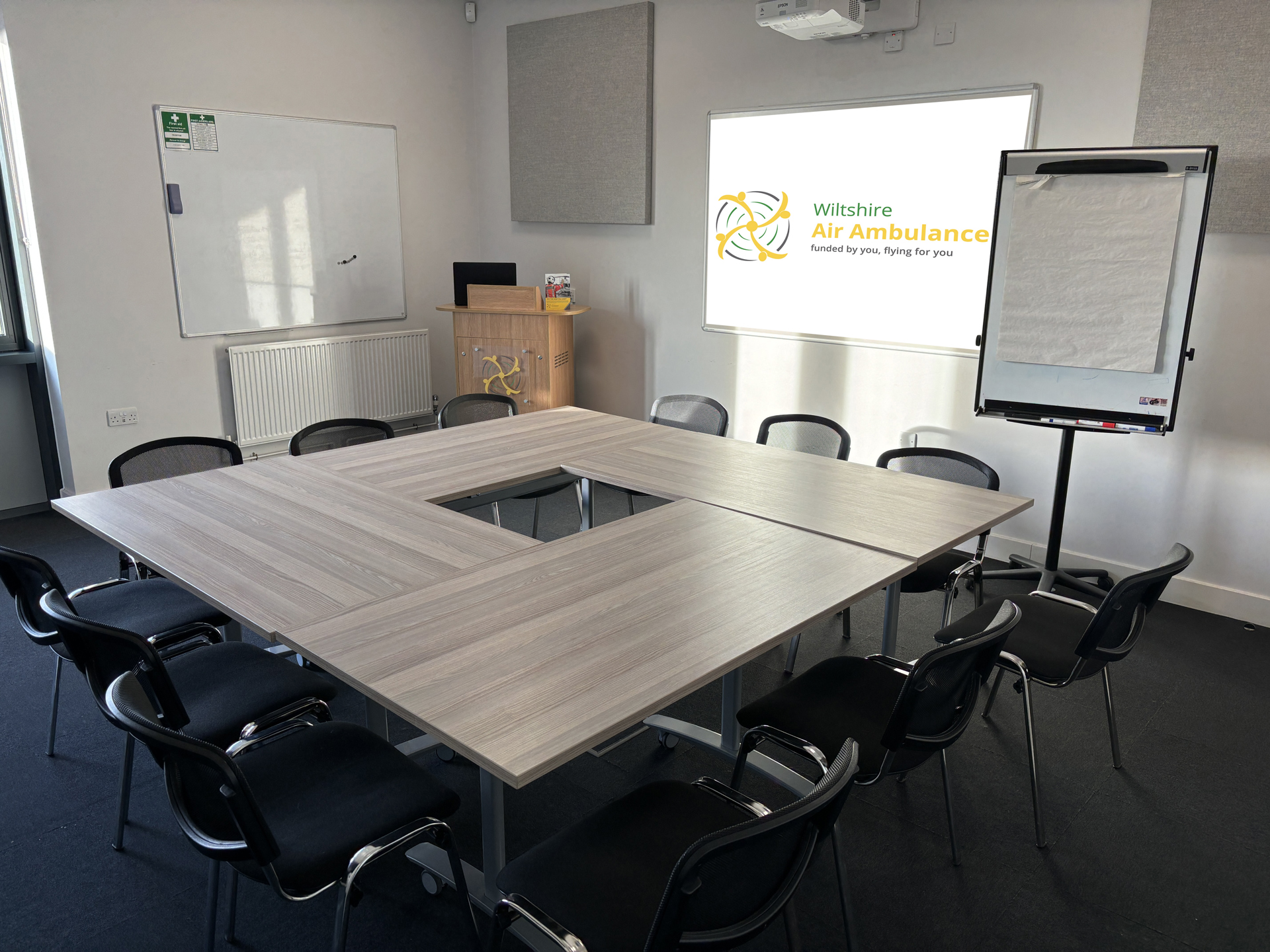 A photo of a hollow square table set up in a small meeting room