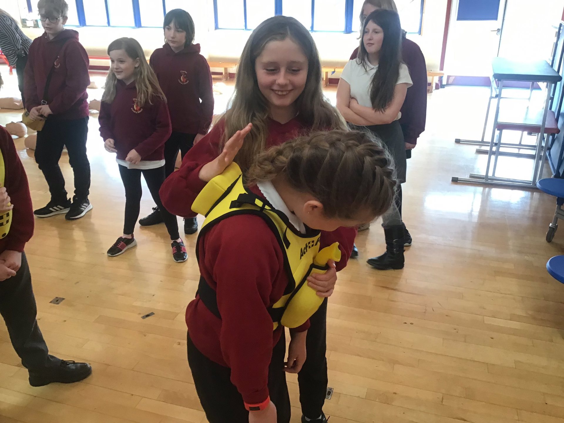 2 school children practicing how to help someone who is choking