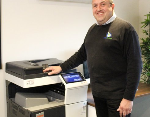 A man posing with a printer